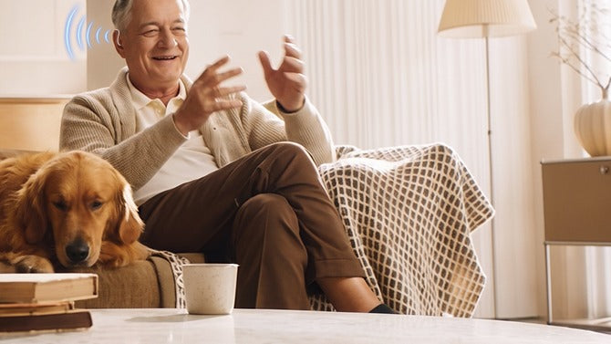 A man laughing on the sofa at home while taking a call